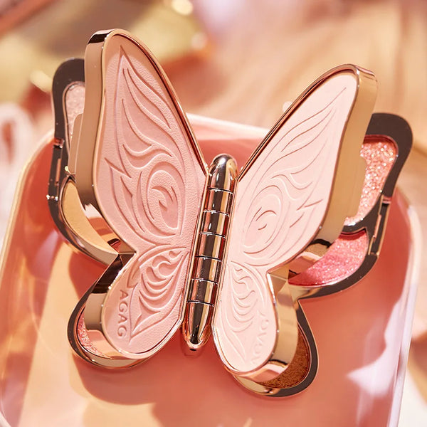 Butterfly-shaped makeup compact with rose gold and black design on a pink background